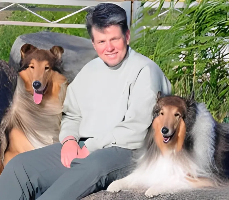 Person sitting with two rough collies